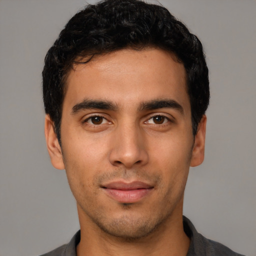 Joyful latino young-adult male with short  black hair and brown eyes