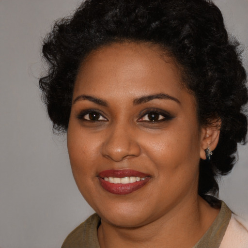 Joyful black young-adult female with short  black hair and brown eyes