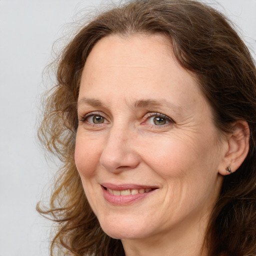 Joyful white adult female with long  brown hair and grey eyes