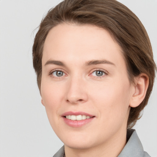 Joyful white young-adult female with short  brown hair and grey eyes