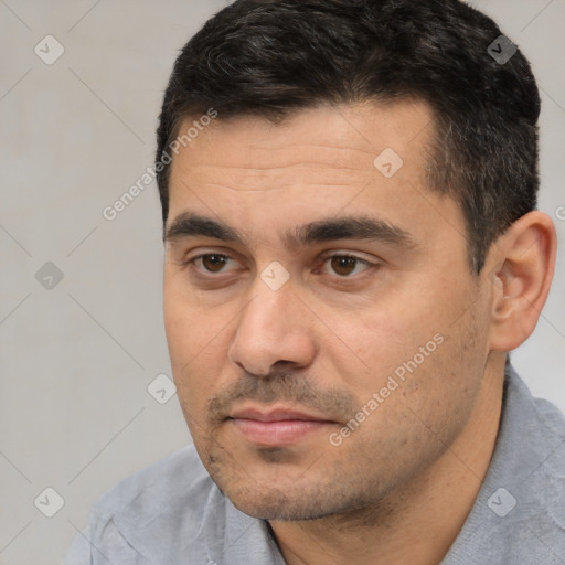 Joyful white adult male with short  black hair and brown eyes