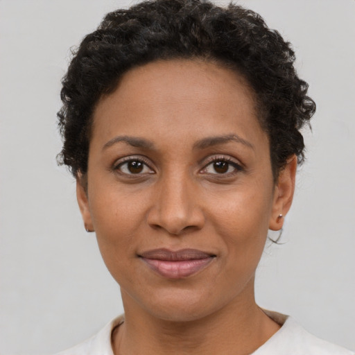 Joyful black adult female with short  brown hair and brown eyes