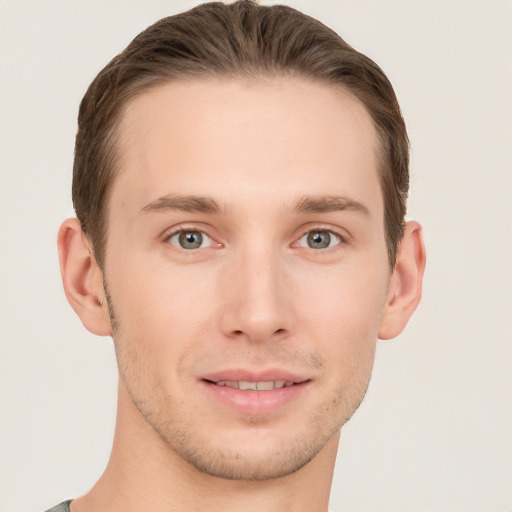 Joyful white young-adult male with short  brown hair and grey eyes