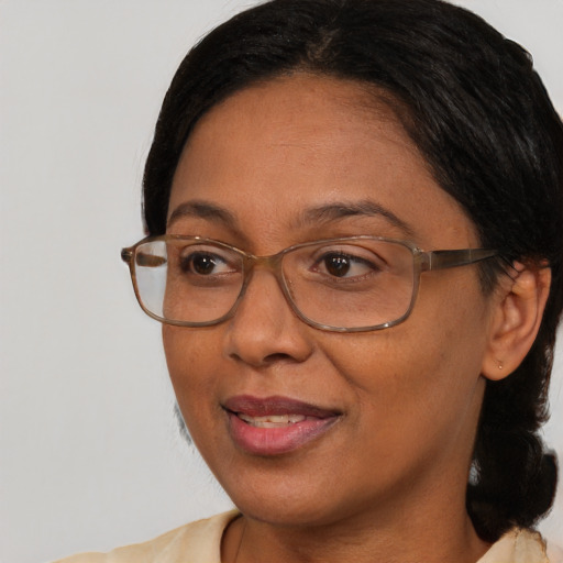 Joyful black adult female with medium  brown hair and brown eyes
