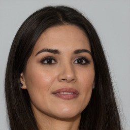 Joyful latino young-adult female with long  brown hair and brown eyes