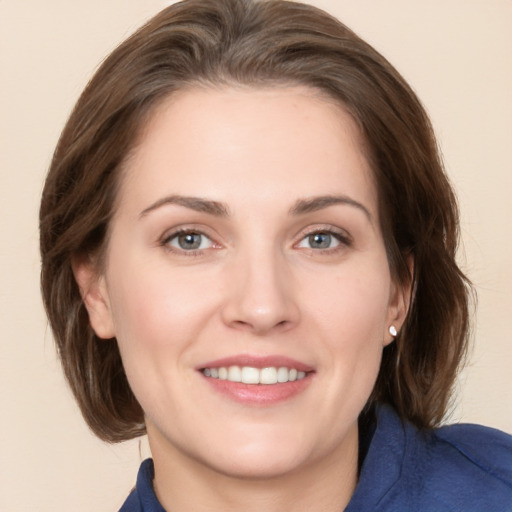 Joyful white young-adult female with medium  brown hair and blue eyes