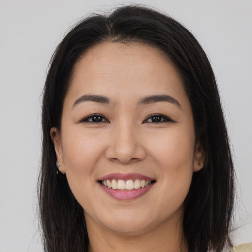 Joyful asian young-adult female with long  brown hair and brown eyes