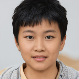 Joyful asian child male with short  black hair and brown eyes