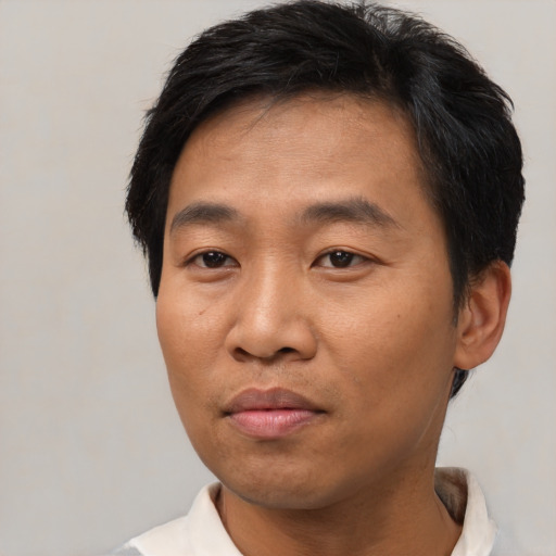 Joyful asian adult male with short  brown hair and brown eyes