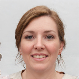 Joyful white young-adult female with medium  brown hair and blue eyes