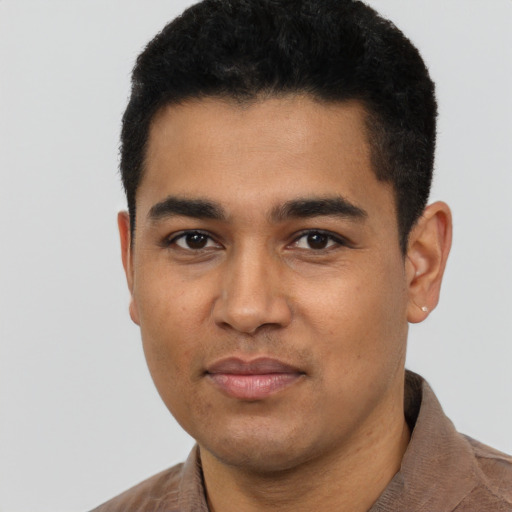 Joyful latino young-adult male with short  black hair and brown eyes