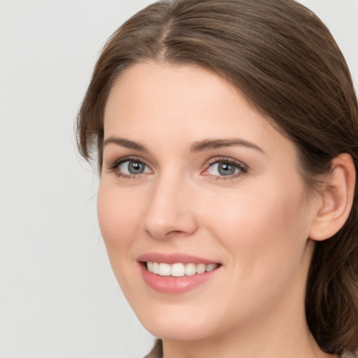 Joyful white young-adult female with medium  brown hair and grey eyes