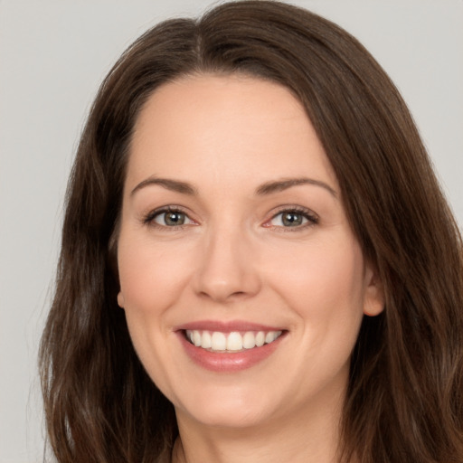 Joyful white young-adult female with long  brown hair and brown eyes