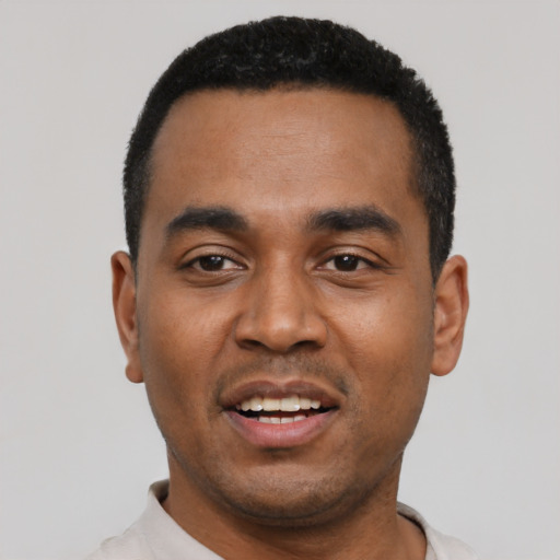 Joyful black young-adult male with short  black hair and brown eyes