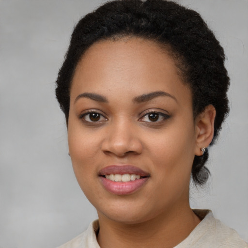 Joyful black young-adult female with short  brown hair and brown eyes