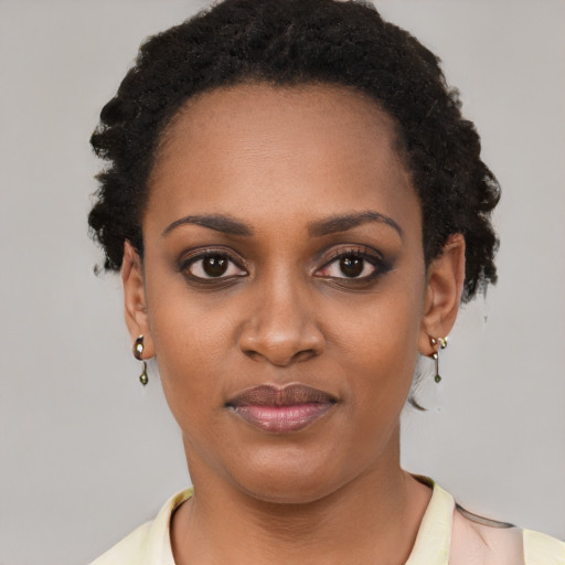 Joyful black young-adult female with short  black hair and brown eyes