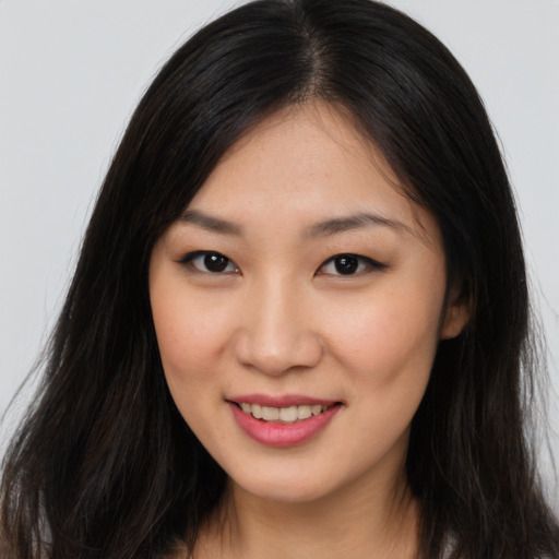 Joyful asian young-adult female with long  brown hair and brown eyes
