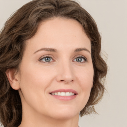 Joyful white young-adult female with medium  brown hair and green eyes