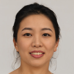 Joyful asian young-adult female with medium  brown hair and brown eyes