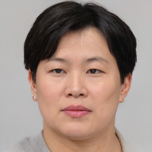 Joyful asian adult female with short  brown hair and brown eyes