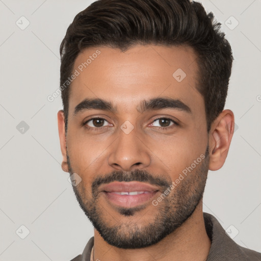 Joyful white young-adult male with short  black hair and brown eyes