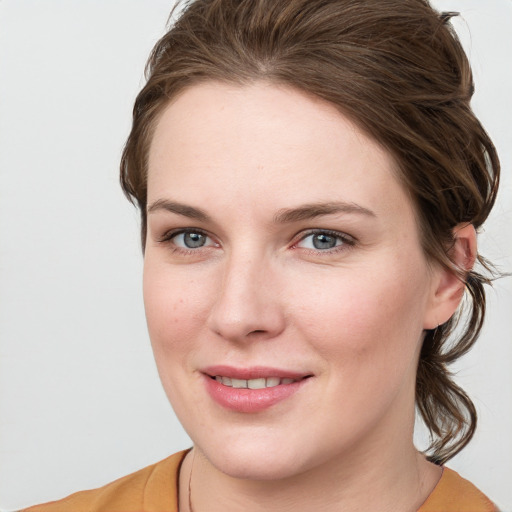 Joyful white young-adult female with medium  brown hair and blue eyes