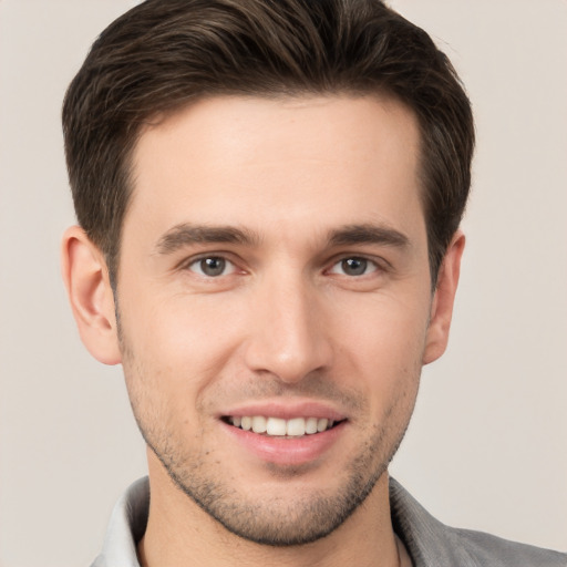 Joyful white young-adult male with short  brown hair and brown eyes