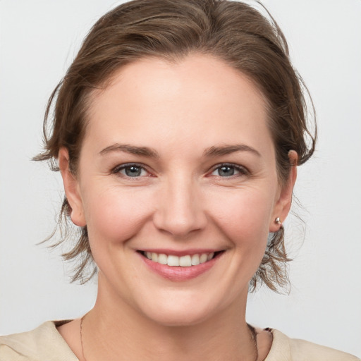 Joyful white young-adult female with medium  brown hair and grey eyes