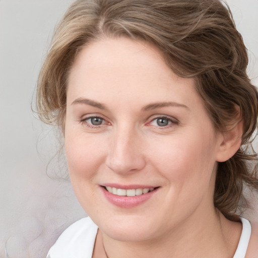 Joyful white young-adult female with medium  brown hair and blue eyes