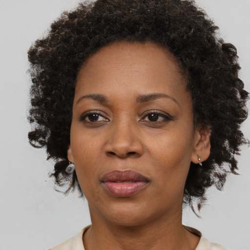 Joyful black adult female with medium  brown hair and brown eyes