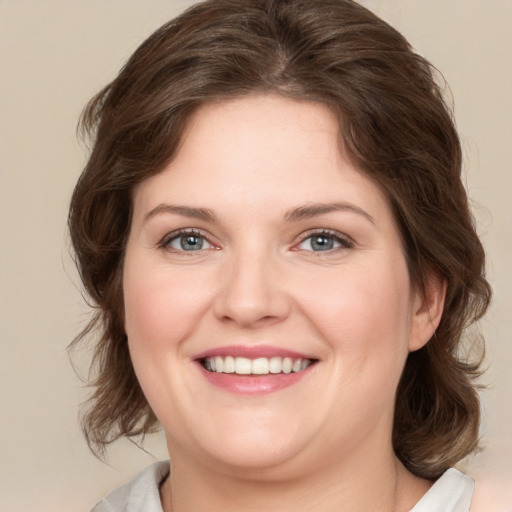 Joyful white young-adult female with medium  brown hair and green eyes