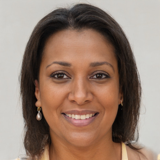 Joyful black young-adult female with long  brown hair and brown eyes
