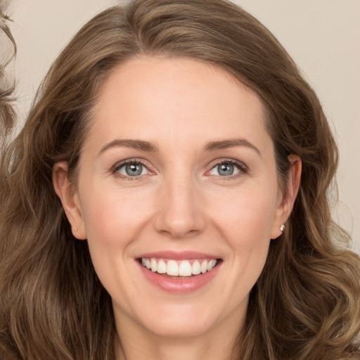 Joyful white young-adult female with long  brown hair and green eyes