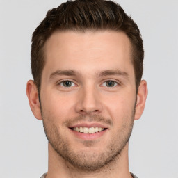 Joyful white young-adult male with short  brown hair and grey eyes