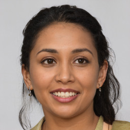 Joyful latino young-adult female with medium  brown hair and brown eyes