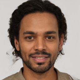 Joyful latino young-adult male with short  brown hair and brown eyes