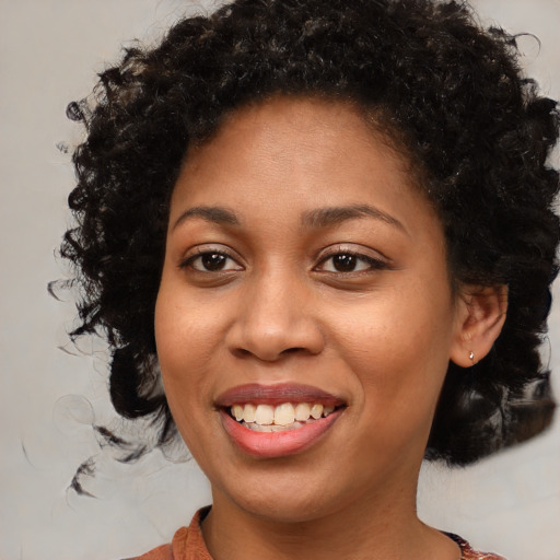 Joyful black young-adult female with medium  brown hair and brown eyes
