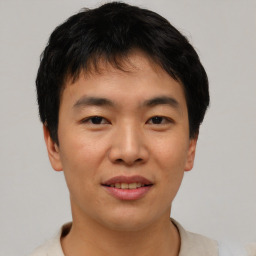 Joyful asian young-adult male with short  black hair and brown eyes