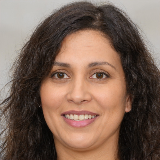 Joyful white adult female with long  brown hair and brown eyes