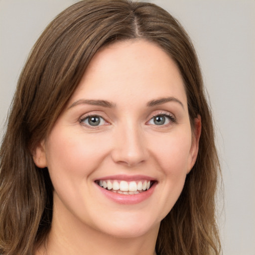 Joyful white young-adult female with long  brown hair and green eyes