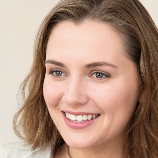 Joyful white young-adult female with long  brown hair and green eyes