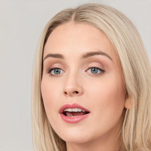 Joyful white young-adult female with long  brown hair and blue eyes