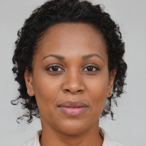 Joyful black adult female with medium  brown hair and brown eyes