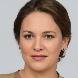 Joyful white young-adult female with medium  brown hair and grey eyes