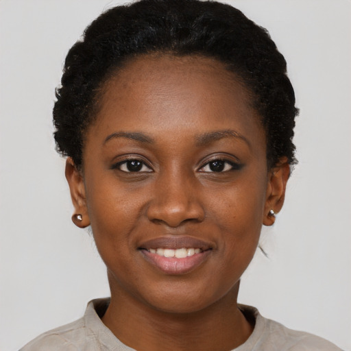 Joyful black young-adult female with short  black hair and brown eyes