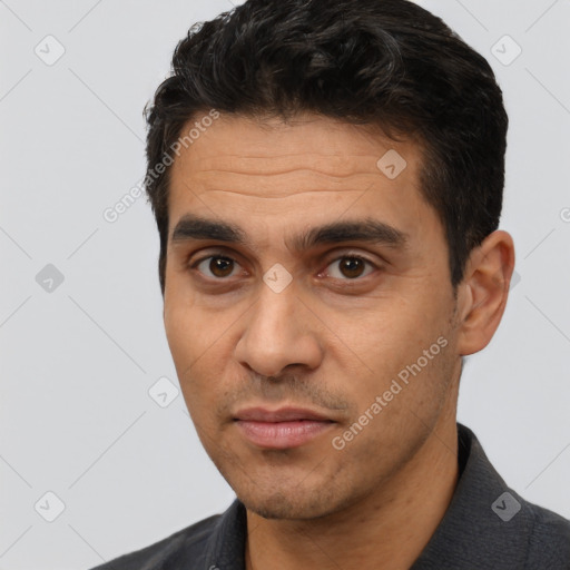 Joyful latino young-adult male with short  black hair and brown eyes