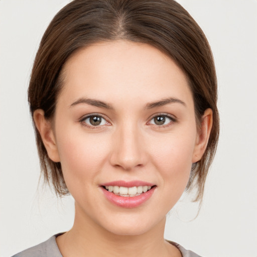 Joyful white young-adult female with medium  brown hair and grey eyes