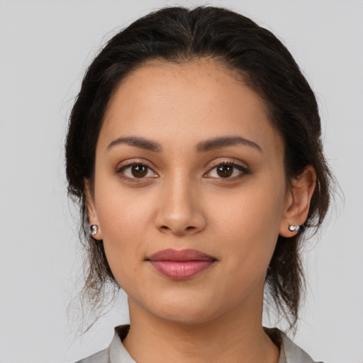 Joyful latino young-adult female with medium  brown hair and brown eyes