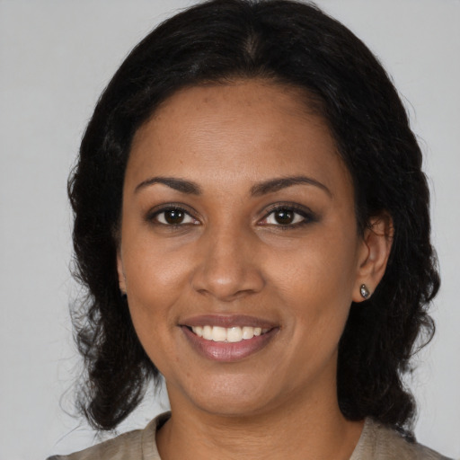 Joyful black adult female with medium  black hair and brown eyes