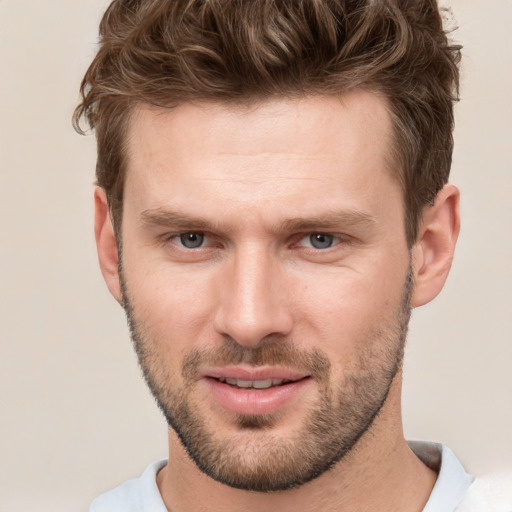 Joyful white young-adult male with short  brown hair and grey eyes